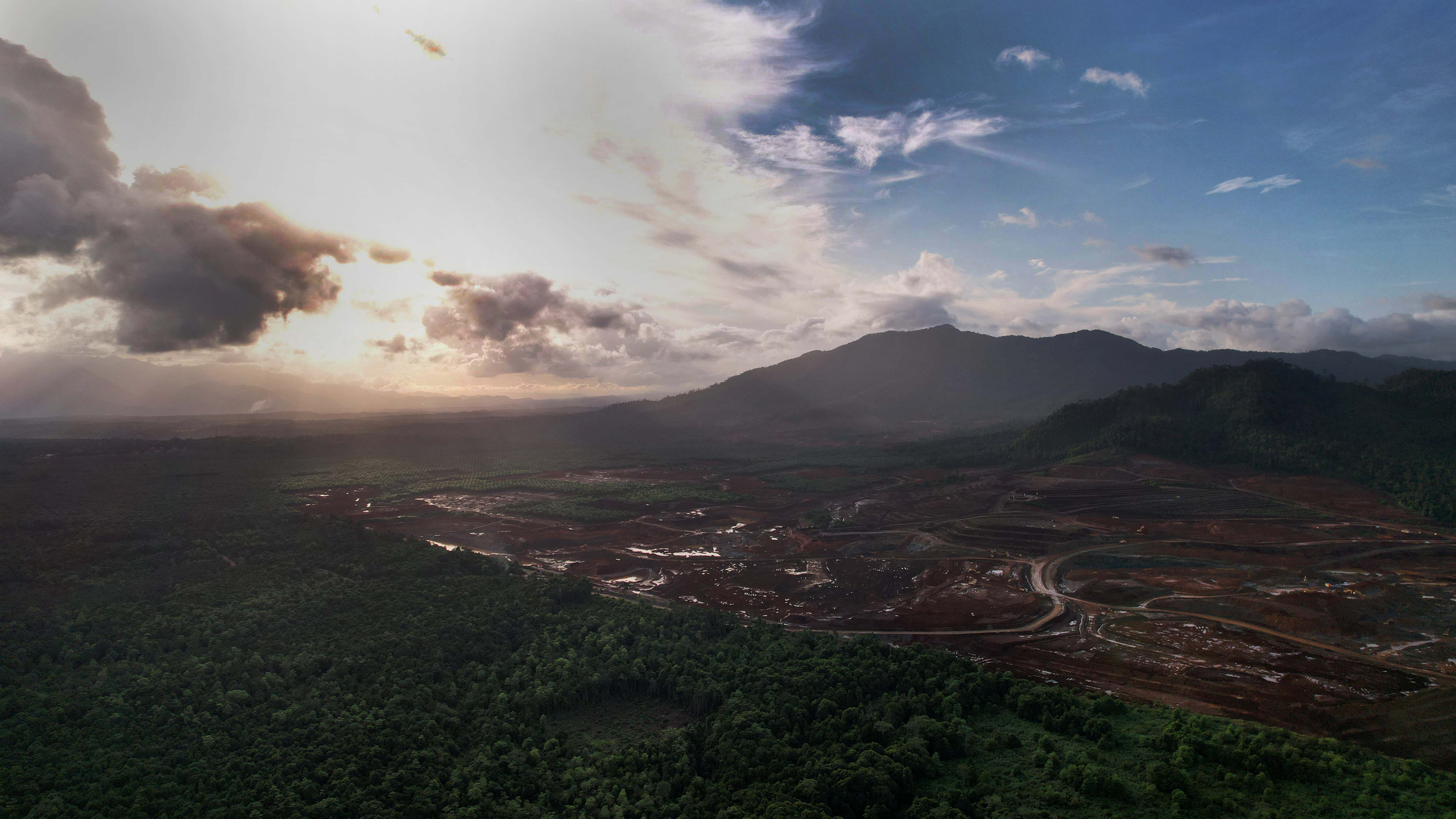 Stripped back landscape from nickel mining country next to green forests.