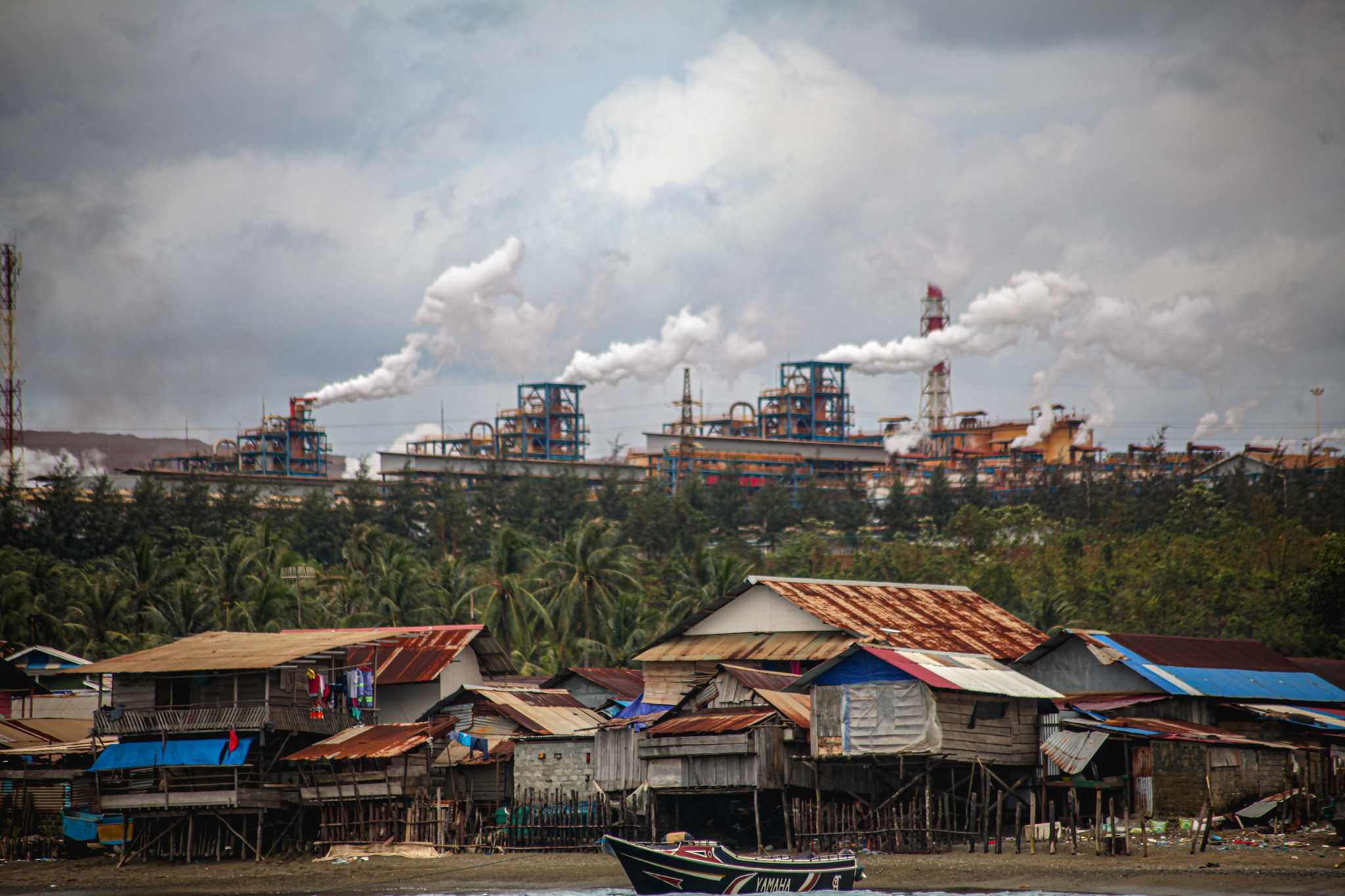 Photo of Kawasi village with Harita Nickel's plant in the background.