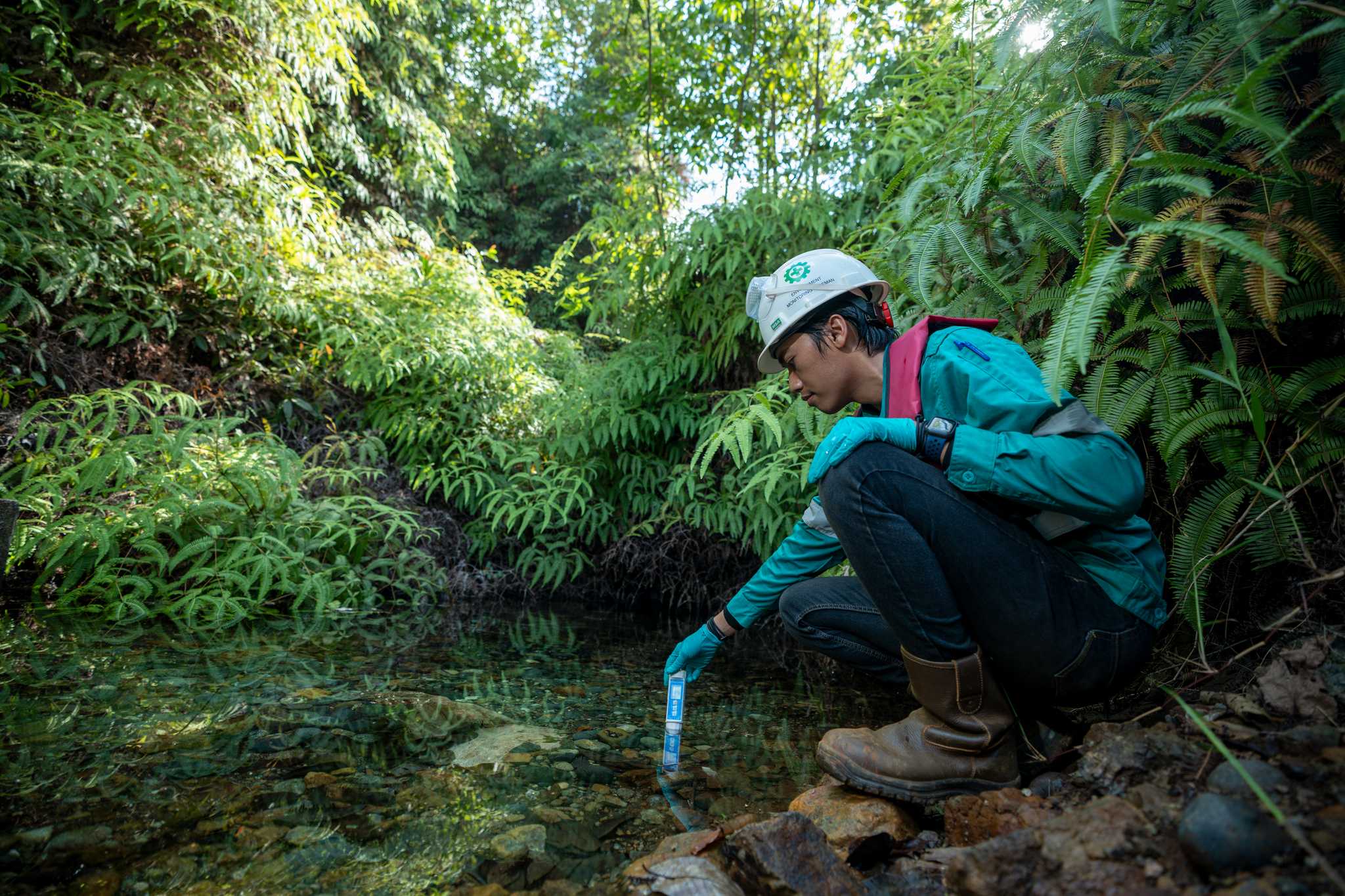 A man testing the water of Kawasi spring.