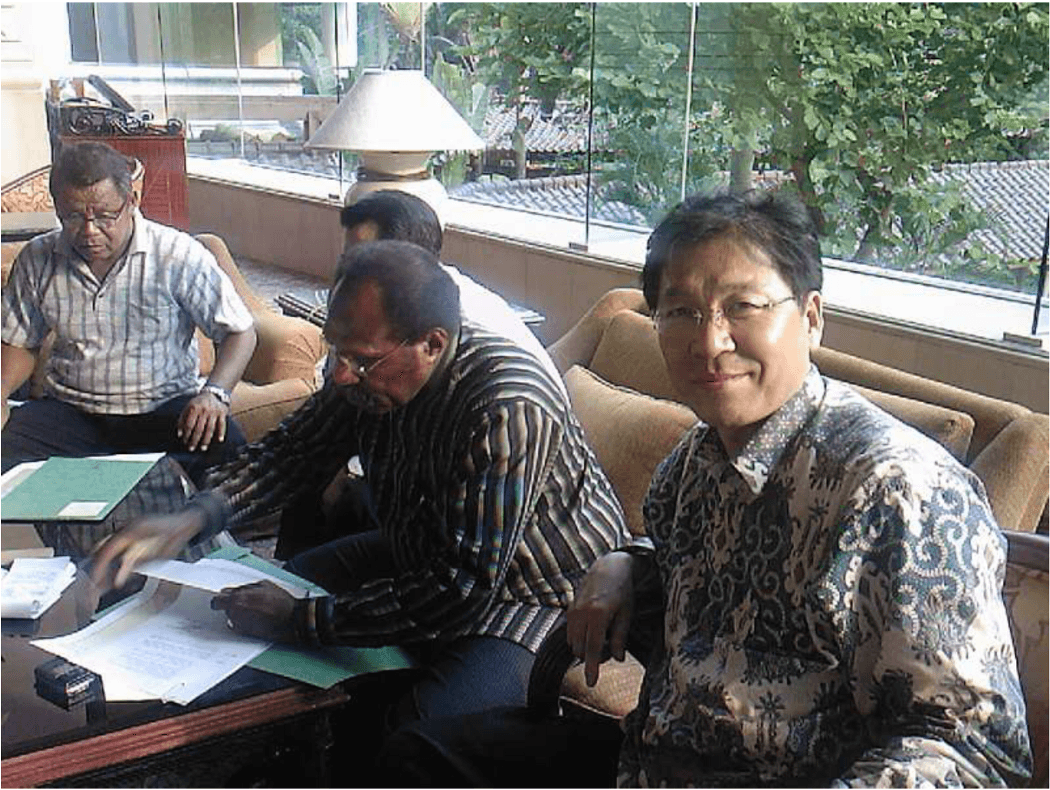 Kim Nam Ku (kanan) tersenyum melihat ke arah kamera ketika Bupati Merauke John Gluba Gebze tampaknya tengah menandatangani sejumlah dokumen perizinan. 
