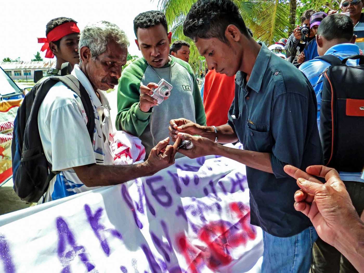 Masyarakat Aru yang berdemo menandatangani nama mereka dengan darah di Dobo.