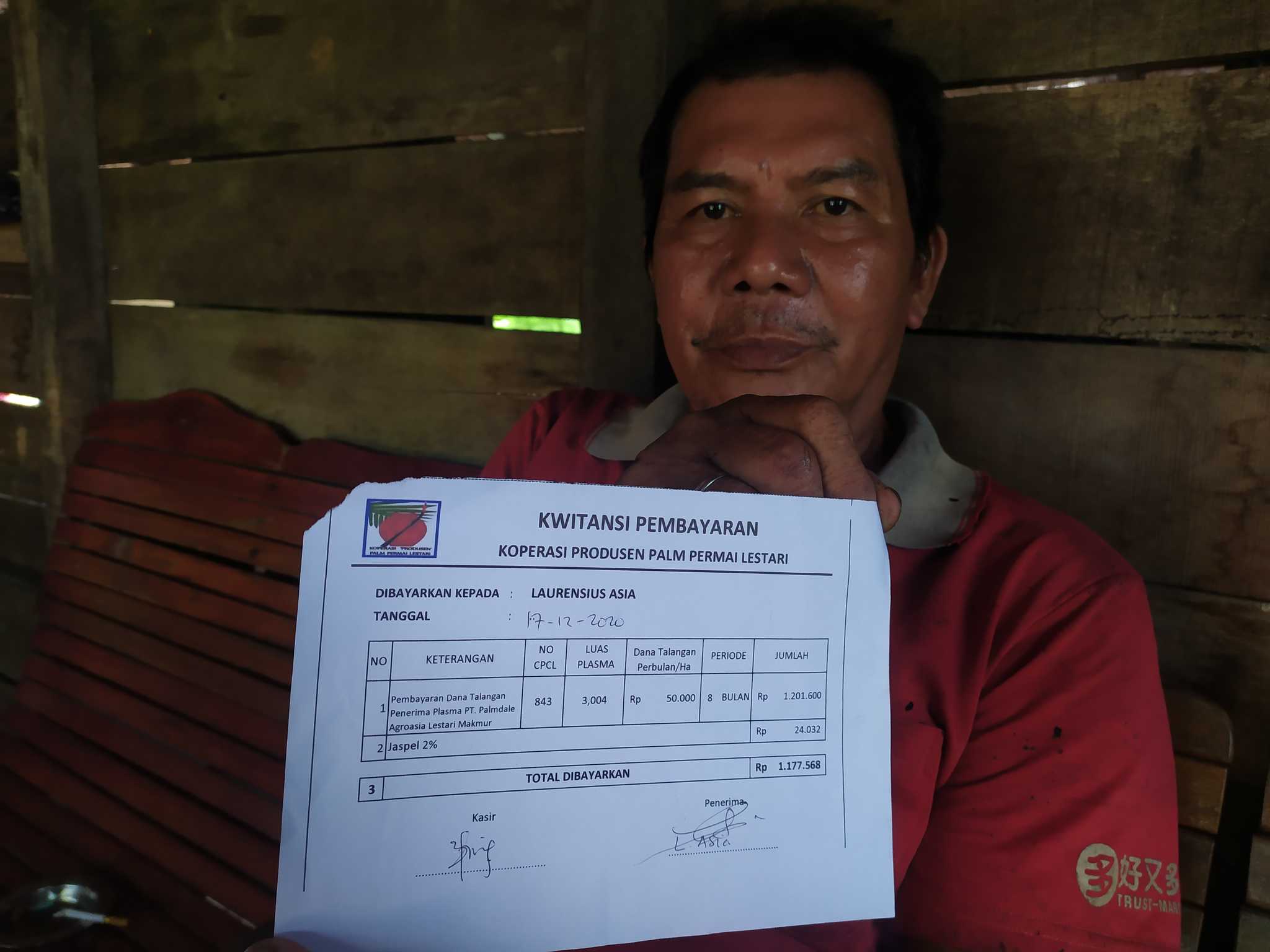 Laurensius Asia, a member of the cooperative in Teluk Bakung, shows a receipt for bailout payments received from Palmdale.